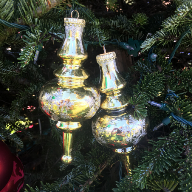 A pair of silver bells on outdoor natural Christmas tree. 