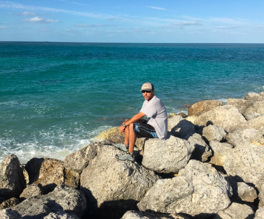 My husband sitting on a jetty while docked in the Bahamas.