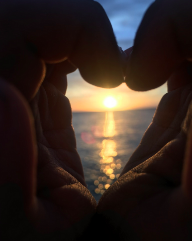 Love and light coming through my sons heart shaped hands circling the sunset.