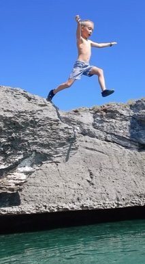 My son taking a leap of faith off a cliff into the bay of Eleuthera