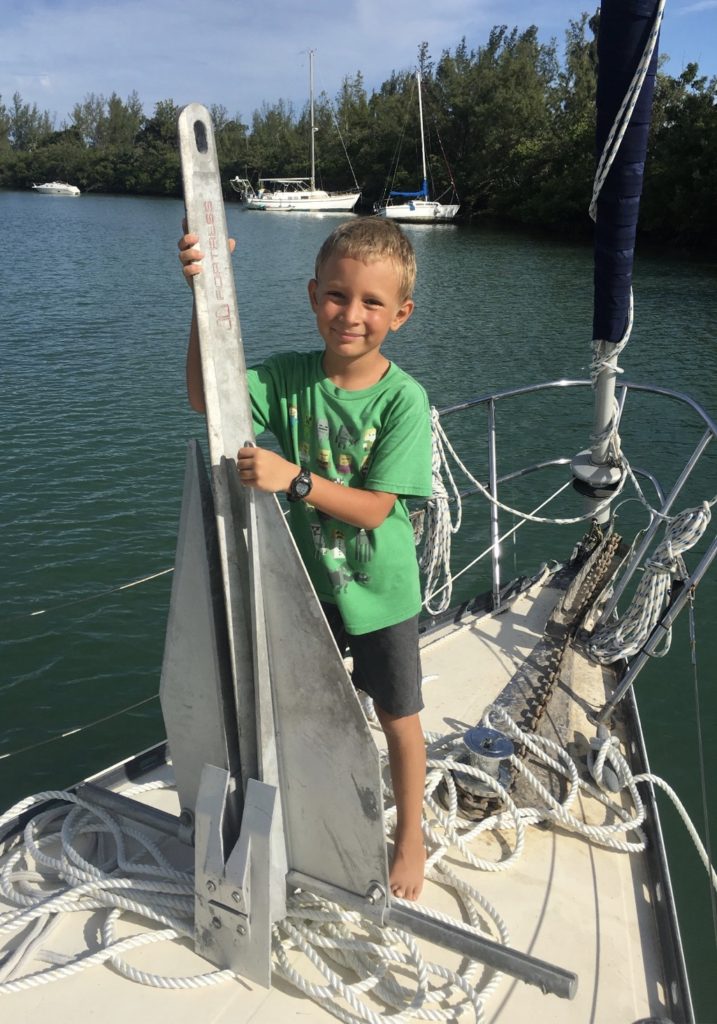 My son holding up our storm anchor for rough winds and seas coming our way.