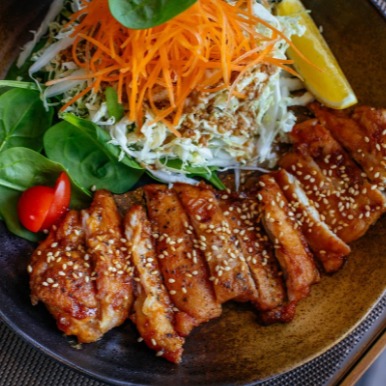 A dish for practicing mindful eating, chicken satay and Asian coleslaw over spinach